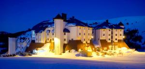 a large building in the snow at night at Monte Baia Uludağ - Full Board Plus in Uludag