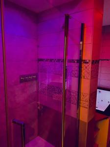 baño con ducha a ras de suelo con luces moradas en Suite Darcy & Spa, en Dijon