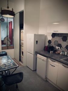 a kitchen with a white refrigerator and a table at Suite Darcy & Spa in Dijon +4 photos