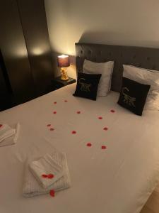 Una cama con pétalos de rosa roja. en Suite Darcy & Spa, en Dijon