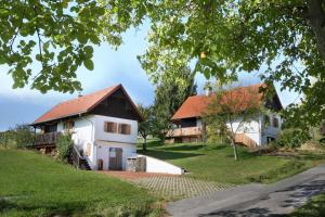 a white house with a red roof next to a house at Kellerstöckl Berg 77 in Sumetendorf