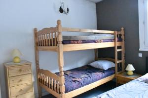 a bedroom with two bunk beds and a night stand at La montagne d'aure in Saint-Lary-Soulan
