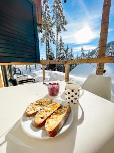 um prato de pão e uma chávena de café numa mesa em Sunshine Apartments Golte - Sauna em Mozirje