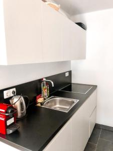 a kitchen with a sink and white cabinets at Sunshine Apartments Golte - Sauna in Mozirje