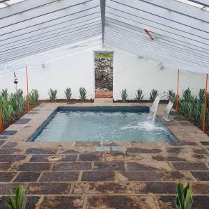 a swimming pool in a tent with a water fountain at Herdade do Ananás in Ponta Delgada