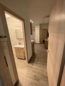 a hallway of a bathroom with a sink and a mirror at Eantos Studios and Suites in Perea