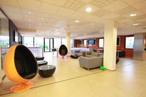 een lobby met banken en stoelen in een gebouw bij ibis Styles Flers in Flers