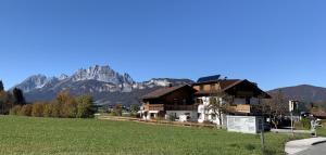 dom w polu z górami w tle w obiekcie Ferienwohnungen Pletzenauer w mieście Sankt Johann in Tirol
