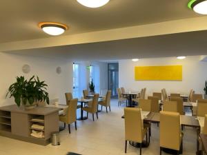 a dining room with tables and chairs in a restaurant at Hotel Garni Colora in Bad Radkersburg