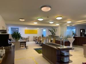 a large kitchen with tables and chairs in a room at Hotel Garni Colora in Bad Radkersburg