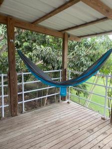 eine Hängematte auf einer Veranda mit einer Holzterrasse in der Unterkunft Herbert's Place in Cabo Rojo