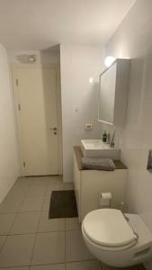 a white bathroom with a toilet and a sink at Laura Compound- Authentic 1 BR charming & specious in Tel Aviv