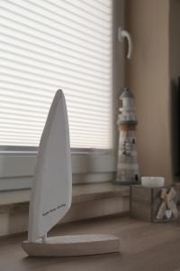 a white surfboard sitting on the floor next to a lighthouse at Möwennest in Sankt Peter-Ording