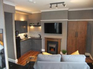 a living room with a white couch and a fireplace at Dewsbury House in Blackpool