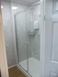 a shower with a glass door in a bathroom at Dewsbury House in Blackpool +46 photos