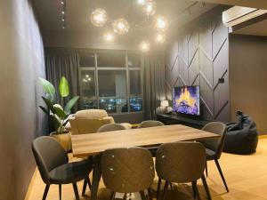 a dining room with a table and chairs and a tv at Serene Studio Imperium Residence Kuantan in Kuantan