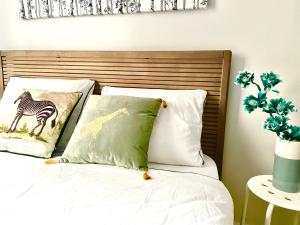 a bed with four pillows at Arina & Julien Dieppe in Dieppe