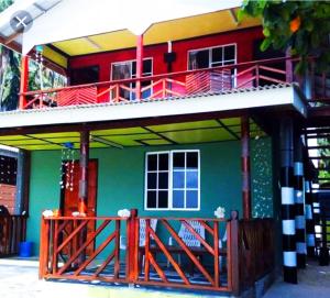 a green and red house with a balcony at Juara Ocean Chalet in Kampong Juara