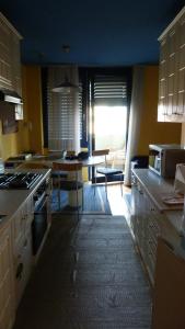 a kitchen with yellow walls and a dining room with a table at Apartment Jena in Ljubljana