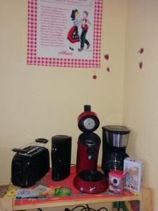 eine Theke mit Kaffeemaschine und eine Uhr darauf in der Unterkunft Les Locations de Stéphanie ,Gite Le Verger in Sondernach