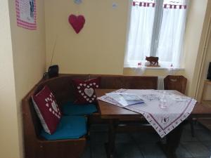 uma mesa e uma cadeira com uma toalha de mesa em Les Locations de Stéphanie ,Gite Le Verger em Sondernach