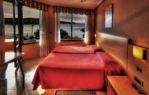 a bedroom with two beds and a large window at Hotel Playa La Arena in Isla