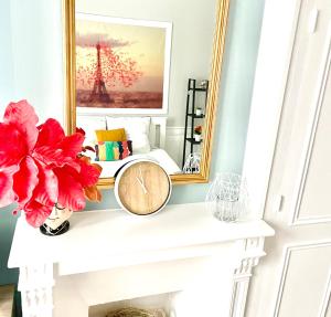 a fireplace with a mirror and a clock on it at Arina & Julien Dieppe in Dieppe
