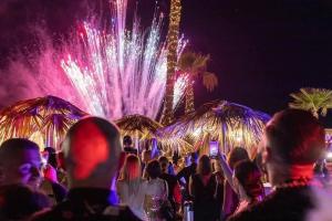 a crowd of people standing in front of a fireworks show at MOOD Sea Stage in Castiglione