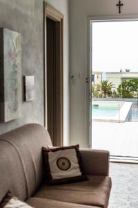 uma sala de estar com um sofá e vista para uma piscina em Blu Corallo Villa em Alcamo