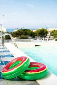 um par de insufláveis sentados ao lado de uma piscina em Blu Corallo Villa em Alcamo