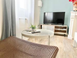 a living room with a table and a tv at Arina & Julien Dieppe in Dieppe