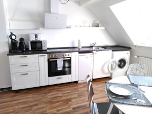 a kitchen with white appliances and a table with chairs at Gemütliche Wohnung zentrumsnah in Pirmasens