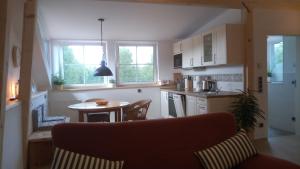 a kitchen with a small table and a kitchen with windows at Ferienhaus Damberg in Übersee