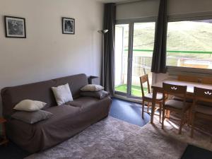 a living room with a couch and a table at Le Skidoux 2*, au pied des pistes, vue montagne in Gourette