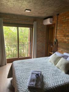 a bedroom with a large bed and a large window at A Estalagem hospedaria in Flores da Cunha +23 photos