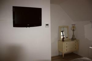 een flatscreen-tv aan de muur van een slaapkamer bij B&B De Veldwachter in Ravels