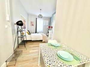 a living room with a table and a bed at Arina & Julien Dieppe in Dieppe