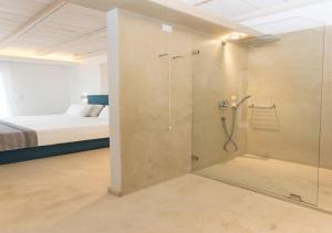 a shower with a glass door in a room with a bed at Princess Of Naxos in Naxos Chora
