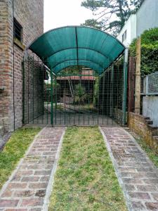 a gate in a building with a fence at Tejas Verdes Alojamiento Familiar in Villa Gesell