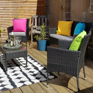 a patio with chairs and a table with colorful pillows at Westwood Cottage in Dundee