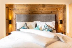 a bedroom with a large bed with a wooden headboard at Apart Jasmin in Ramsau