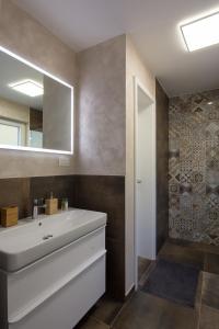 W łazience znajduje się biała umywalka i lustro. w obiekcie The Valley Queens w mieście Bovec