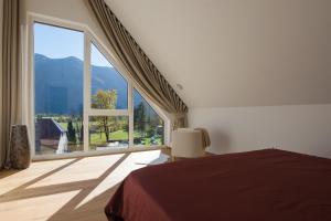 a bedroom with a large window and a bed and a chair at The Valley Queens in Bovec