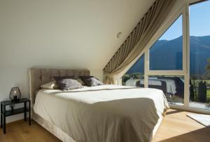 um quarto com uma cama grande e uma janela grande em The Valley Queens em Bovec