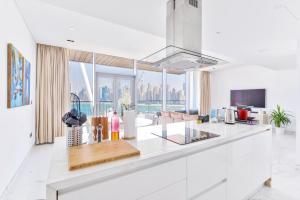 een keuken met witte werkbladen en een groot raam bij Island Paradise - Stylish 2BR on Bluewaters Island in Dubai