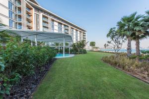 a large building with a lawn in front of the ocean at Island Paradise - Stylish 2BR on Bluewaters Island in Dubai