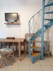a living room with a staircase and a table and a television at Da Ale in Dormelletto