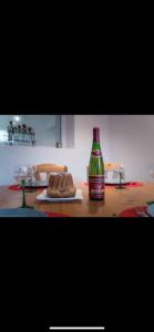 Chez Ben et Maé في روفاك: زجاجة من المشروبات الغازية موضوعة على طاولة مع كعكة