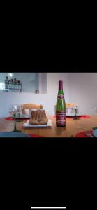 a bottle of soda sitting on a table with a cake at Chez Ben et Maé in Rouffach