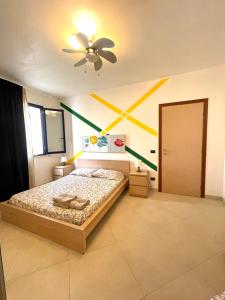 a bedroom with a bed and a ceiling fan at Casa Serra in Porto Palo